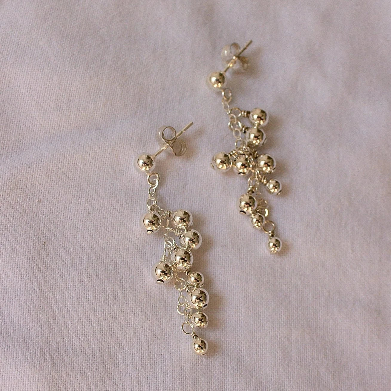 dangling sterling silver earrings on white cloth