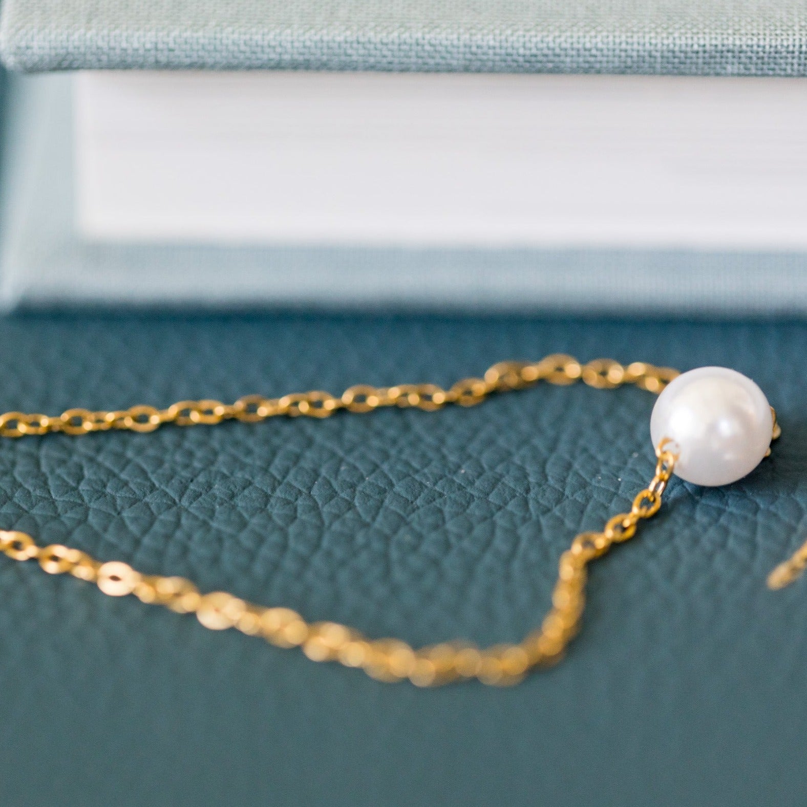 gold bracelet with pearl on table 