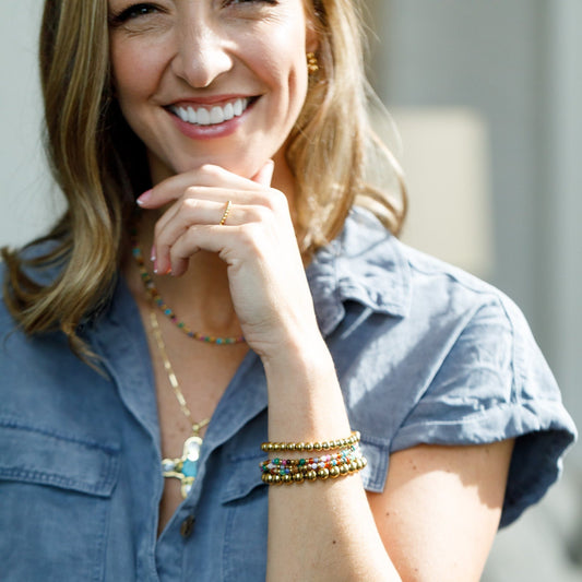 gold bead bracelet stack on left arm 