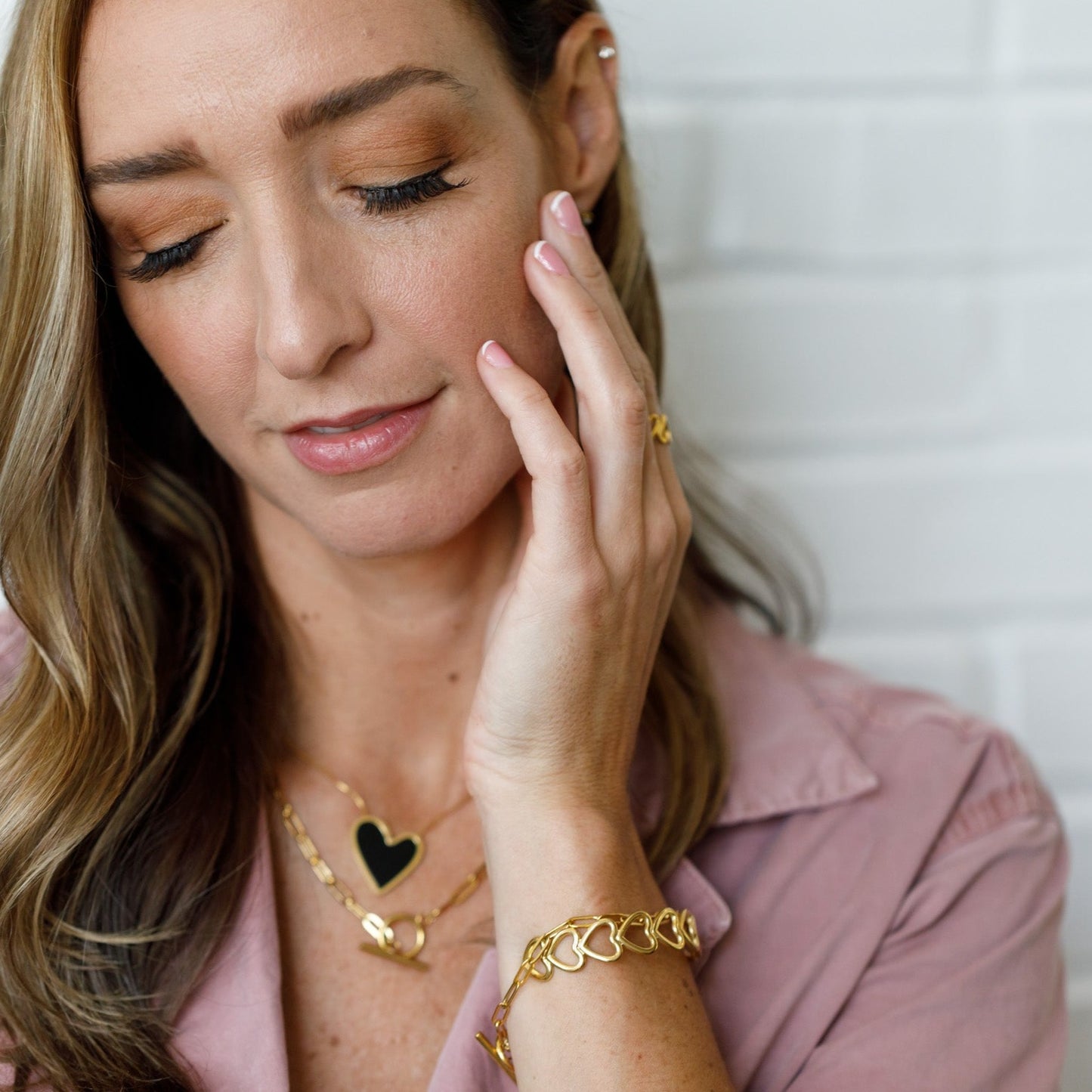 gold open heart cuff bracelet on left wrist 